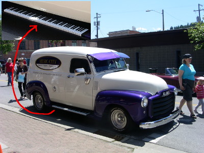 [A parked purple and tan van with two doors and an awning over the windwhield. Along the step to get inside, piano keys have been painted. A separate photo with a close view of the step is in the upper left corner of the image and a red arrow goes from the van to the closeup view.]